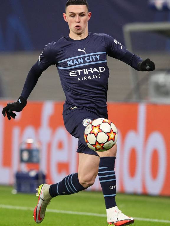 Phil Foden, do Manchester City, domina a bola em jogo da Champions League; seu uniforme é azul-escuro