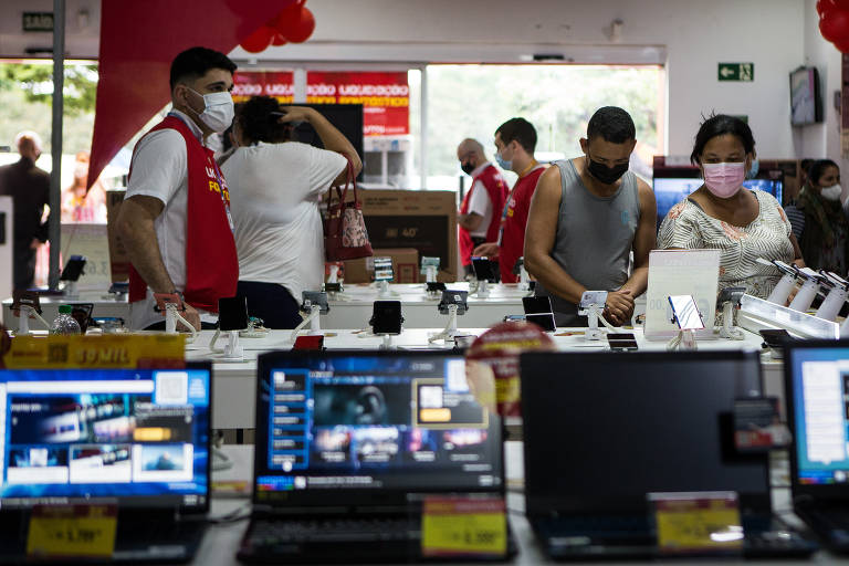 Consumidores observam produtos durante liquidação em uma loja