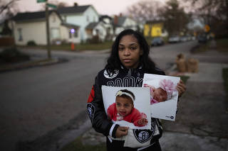 Vanecia Kirkland, holds photos of her daughters Ava and Alyse Williams, who were shot and killed by their father, in Columbus, Ohio, Dec. 21, 2021. (Maddie McGarvey/The New York Times)