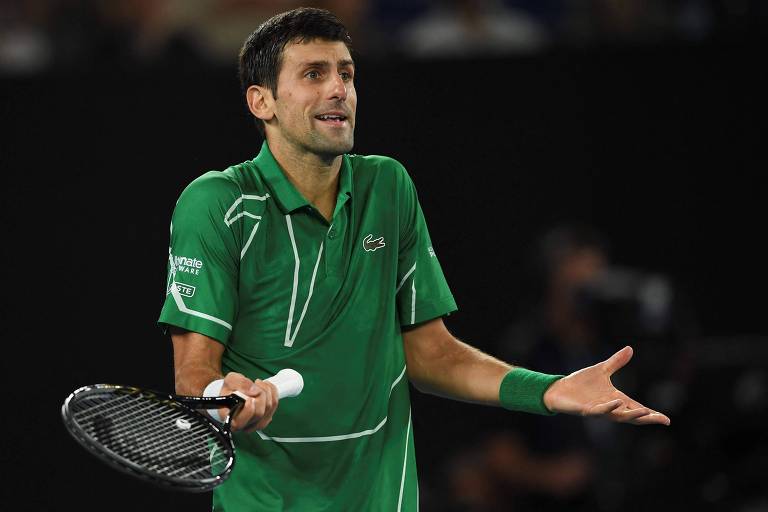 Djokovic, de camiseta verde e raquete em uma das mãos, gesticula em discussão durante a final do Australian Open de 2020