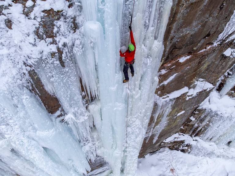Alpinista é visto escalando parede rochosa coberta de gelo em meio à natureza do parque Robinson, nos Estados Unidos