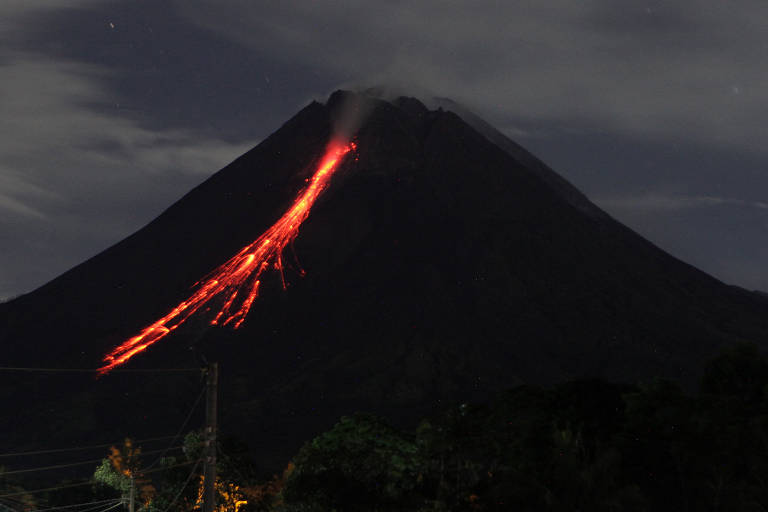 O Monte Merapi, o vulcão mais ativo da Indonésia, expele cinzas e lava de seu pico visto de Sleman, em Yogyakarta