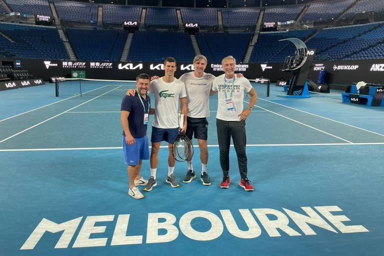 Novak Djokovic e sua equipe posam para foto em quadra de tênis