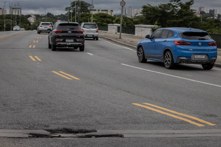 Carros passam por buraco na avenida Rudge, na entrada da ponte da Casa Verde, no sentido Santana, zona central de São Paulo 