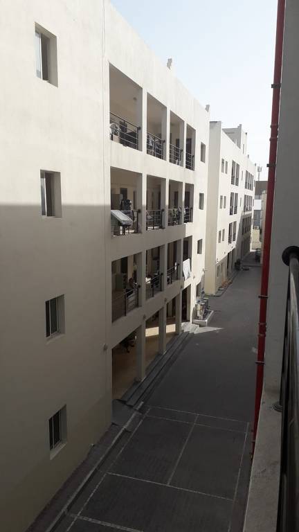 Foto dos corredores internos de um conjunto habitacional em Doha, no Qatar, mostrando os outros apartamentos do local