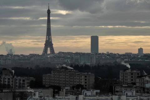 This picture taken on January 6, 2022, shows a view of Paris with the Eiffel tower(L) and the Montparnasse tower, under a cloudy sky in Puteaux. (Photo by JOEL SAGET / AFP) ORG XMIT: 582