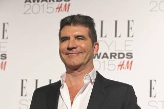 Simon Cowell poses with his award for 