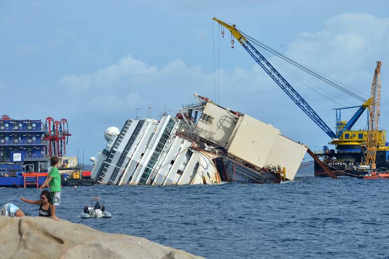 Casco do Costa Concordia no porto da ilha Giglio, na Itália; mais de um ano e meio depois, embarcação continuava tombada no local