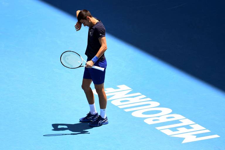 Djokovic enxuga o suor da testa em quadra