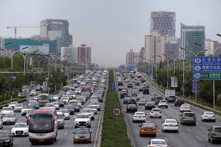FILE PHOTO: Cars drive on the road during the morning rush hour in Beijing