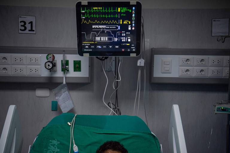Paciente com Covid em UTI, cercado por máquinas