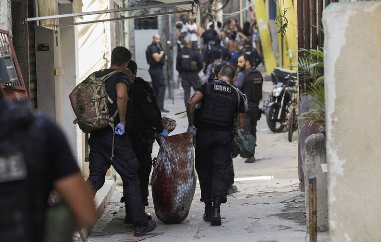 Policiais carregam corpo durante operação na favela do Jacarezinho, a mais letal da história, com 28 pessoas mortas pela polícia do Rio de Janeiro