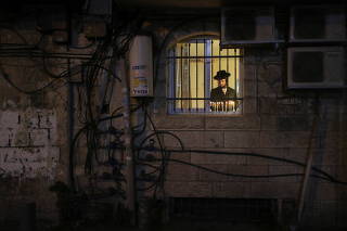 Ultra-Orthodox Jews light candles on the last night of Hanukkah, in Jerusalem