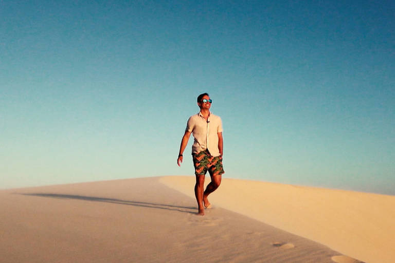 Cena de série representando um homem a caminhar sobre dunas