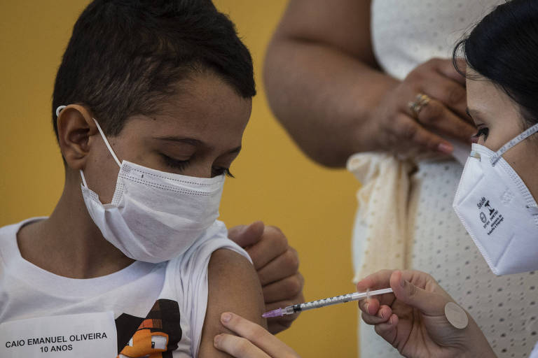 Na foto, Caio Emanuel de Oliveira, 10, recebe o imunizante da Pfizer contra a Covid-19