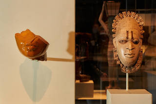 From left, ÒFragment of a WomanÕs FaceÓ from Egypt, ca. 1353-1336 B.C., and ÒLyoba (Queen Mother) Pendant MaskÓ from Nigeria, 16th century, on display in ÒThe African Origin of CivilizationÓ at the Metropolitan Museum of Art in New York, Dec. 28, 2021. (Seth Caplan/The New York Times)