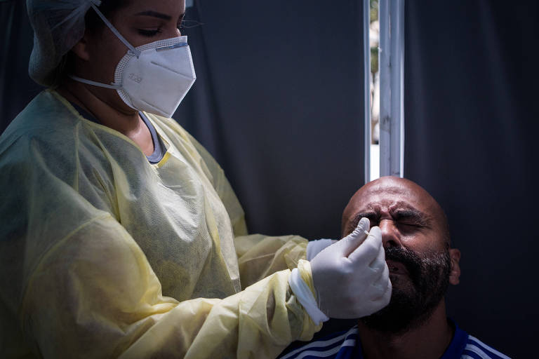 enfermeira teste homem para covid com swab nasal