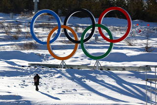 A person walks past the Olympic rings in the Zhangjiakou competition zone ahead of the Beijing 2022 Winter Olympics in Beijing