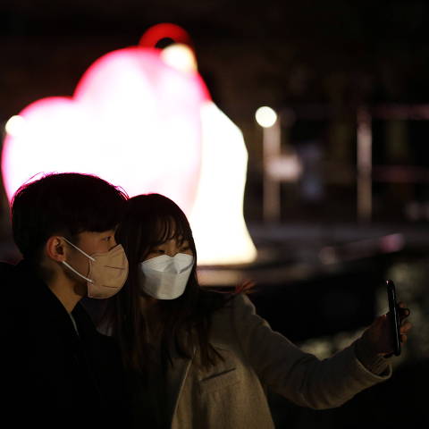 A couple wearing masks to avoid contracting the coronavirus disease (COVID-19) takes selfie in front of heart-shaped lantern during the 2021 Seoul Lantern Festival in Seoul, South Korea, November 26, 2021. REUTERS/Kim Hong-Ji ORG XMIT: PPPKHJ02