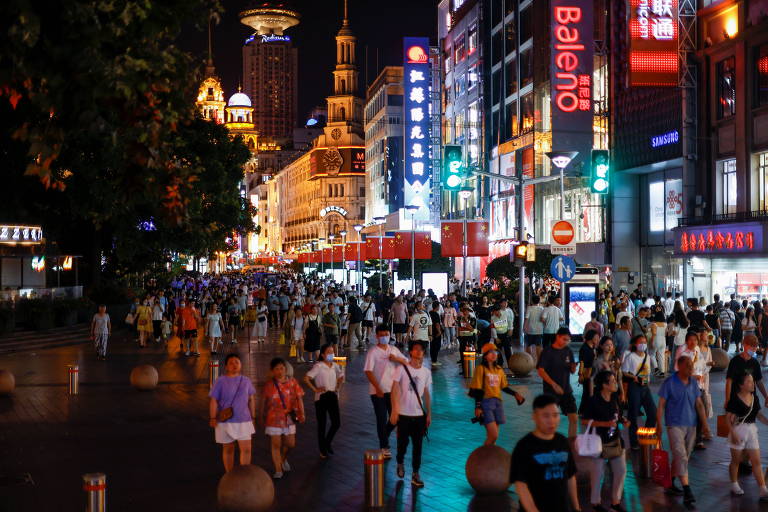 Pessoas caminham por área comercial de Xangai, na China