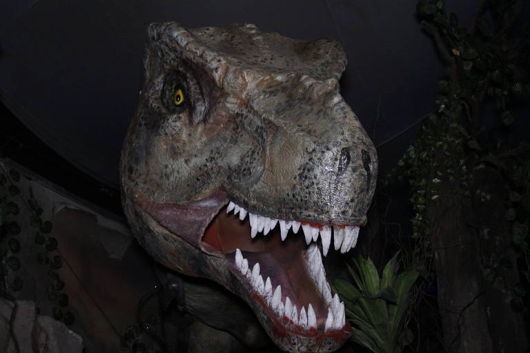 O passeio Jurassic Aquarium coloca visitantes para passear num carrinho sobre trilhos rodeado de dinossauros
