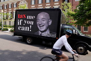 FILE PHOTO: A video protest sign on a truck paid for by the Patriotic Millionaires drives past a mansion owned by Amazon founder Bezos in Washington
