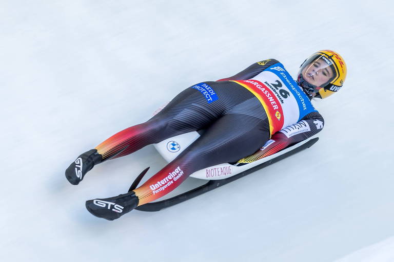 Atleta na pista com as costas encostadas no trenó