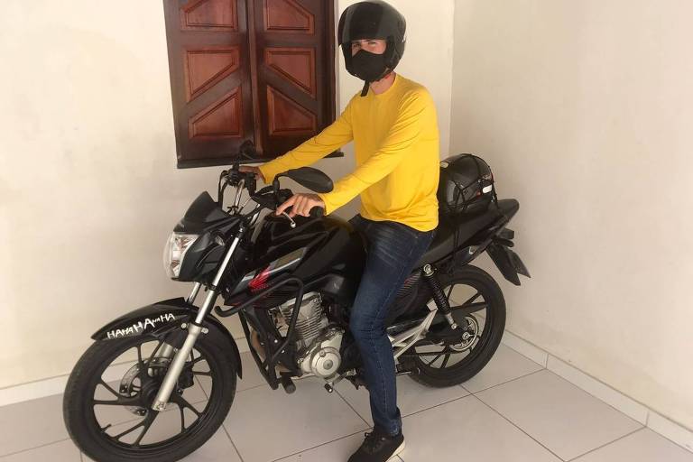  De capacete e camiseta amarela, Gabryel Miranda Soares, 25,  posa para foto com sua motocicleta, que usa para trabalhar