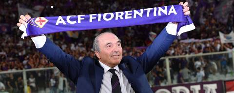 (FILES) In this file photo taken on August 24, 2019 (FILES) In this file photo taken on August 24, 2019 Fiorentina's owner, Italian American billionaire businessman Rocco Commisso holds a fans' scarf prior to the Italian Serie A football match Fiorentina vs Napoli on August 24, 2019 at the Artemio-Franchi stadium in Florence. - A quarter of Italian Serie A clubs - five out of twenty - are now American-owned, with AS Roma (acquired by businessman Dan Friedkin in 2020), Fiorentina (acquired by Italian-American businessman Rocco Commisso in 2019), AC Milan (controlled by the Elliott fund since 2018) and recently Parma (the Krause group became the majority shareholder in September). (Photo by Andreas SOLARO / AFP)