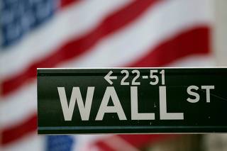 FILE PHOTO: A Wall Street sign hangs on a signpost in front of the New York Stock Exchange