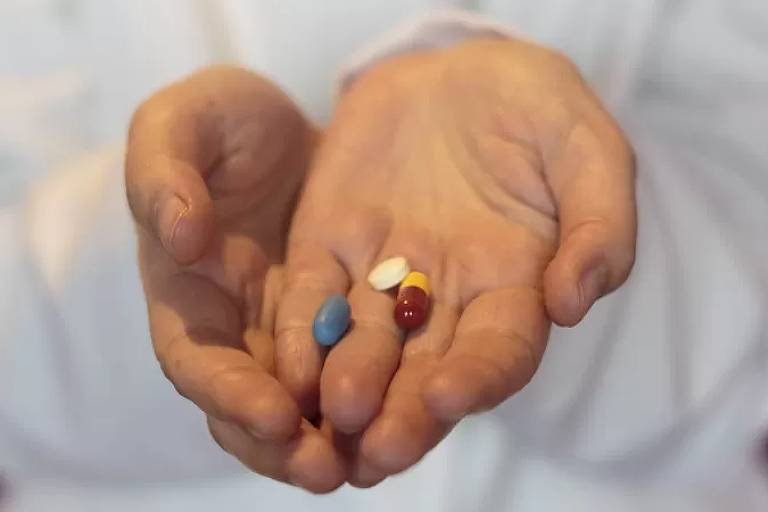 Imagem em close mostra as comprimidos na mão de uma pessoa