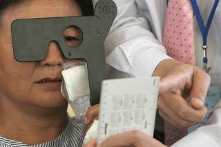 A cataract patient reads after undergoing surgery at a hospital in Xilinhot