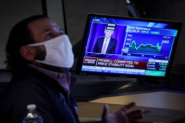 Operador trabalha na Bolsa de Valores de Nova York, onde monitor mostra o presidente do Fed, Jerome Powell