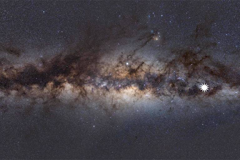 Uma imagem mostra a Via Láctea vista da Terra, com um ícone de estrela mostrando a posição do misterioso objeto