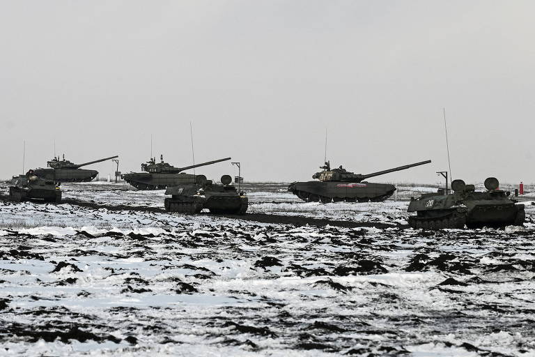 Blindados anfíbios MT-LB russos passam ao largo de tanques durante exercícios militares na região de Rostov, perto da Ucrânia