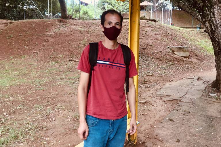 De pé, com máscara e camisa vermelha, o vendedor Thiago de Campos, que ficou desempregado