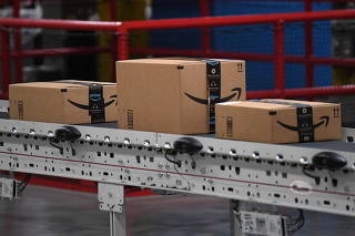 FILE PHOTO: Packed and labeled boxes ready for delivery move along a conveyor belt at the Amazon fulfillment center in Baltimore