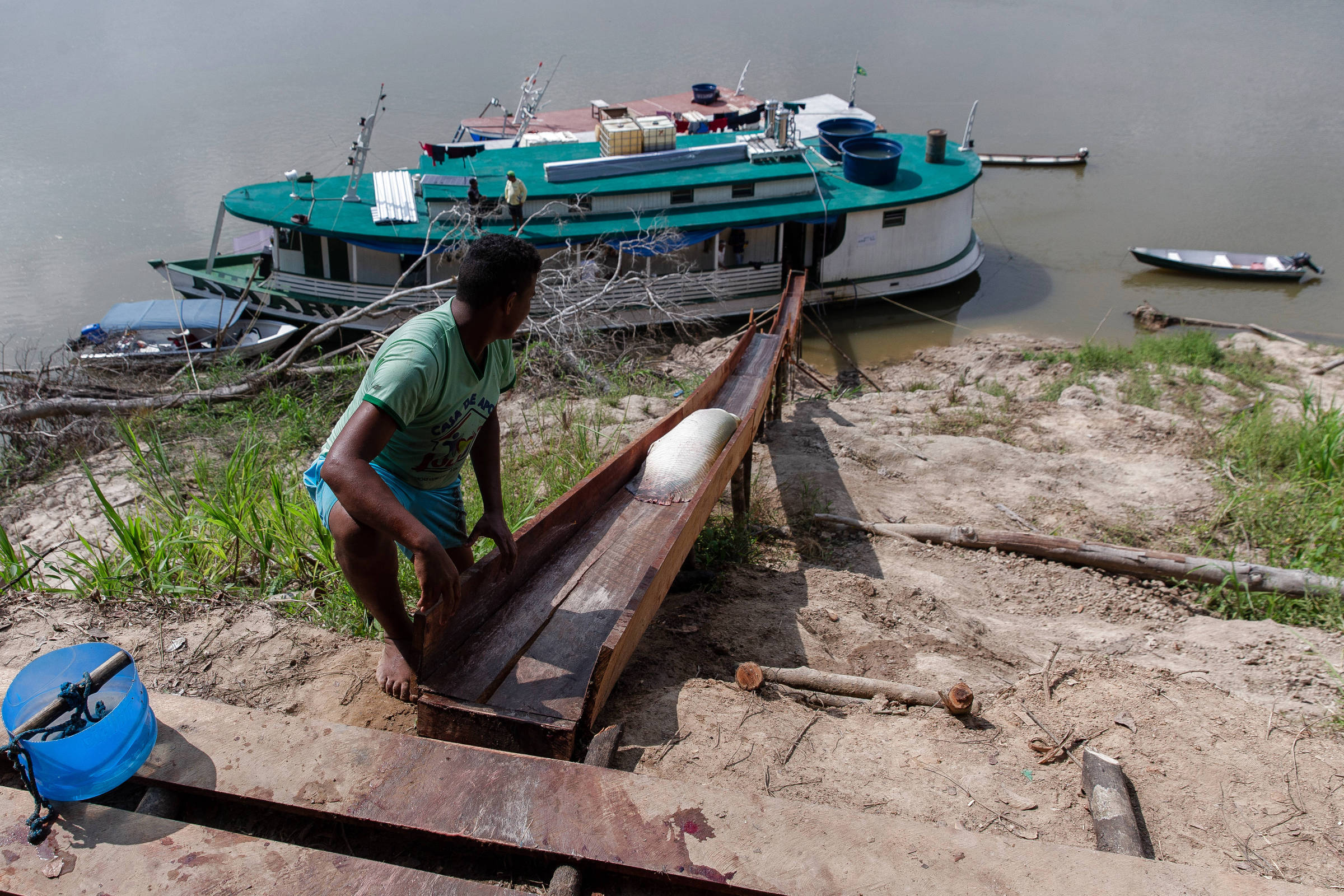 Homem lança um pirarucu para ser limpo em um barco da comunidade Xibauazinho, nas margens do rio Juruá