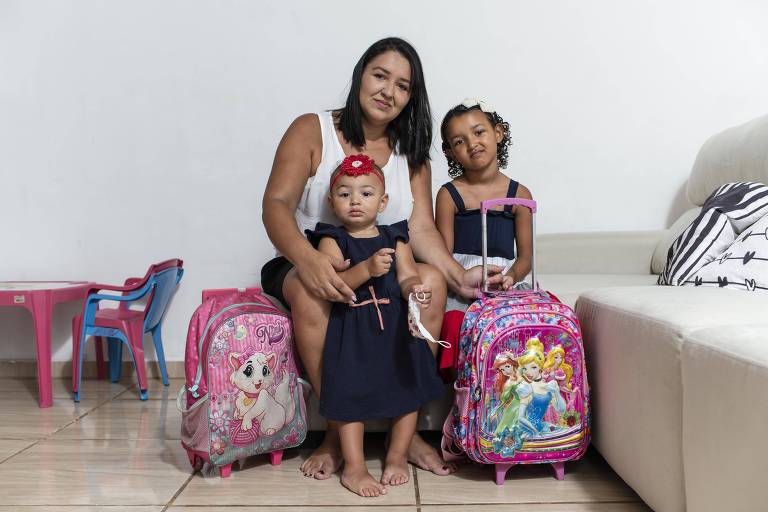 Licia e suas duas filhas, Giovanna, 5, e Liz, 1, em sua casa no Rio de Janeiro. A mãe esta em duvida se deve levar as crianças para a escola devido a explosão de casos de Covid-19