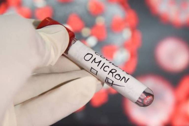 Pessoa segura tubo com fita em que está escrito "Omicron"