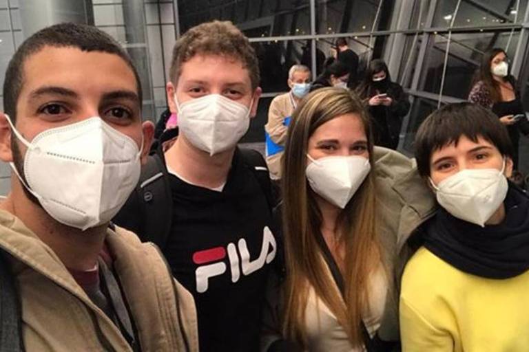 Dois homen e duas mulheres de mascara em foto no aeroporto