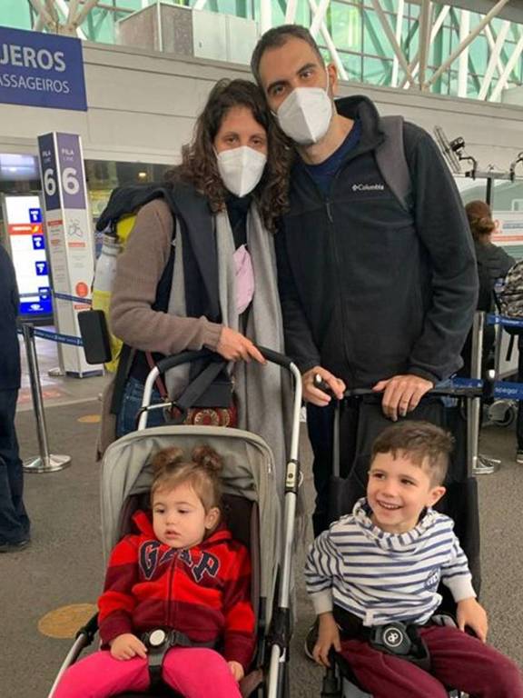 Homem, mulher e duas crianças em foto no aeroporto