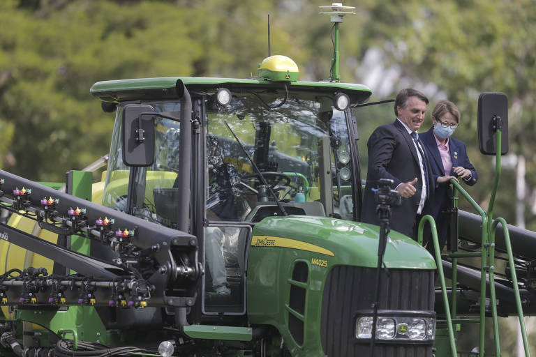 Presidente Jair Bolsonaro ao lado de Tereza Cristina sobre trator