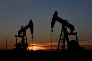 FILE PHOTO: Pump jacks operate at sunset in an oil field in Midland