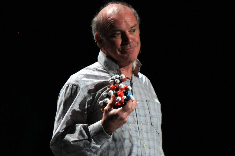Homem com camisa xadrez segura modelo de molécula