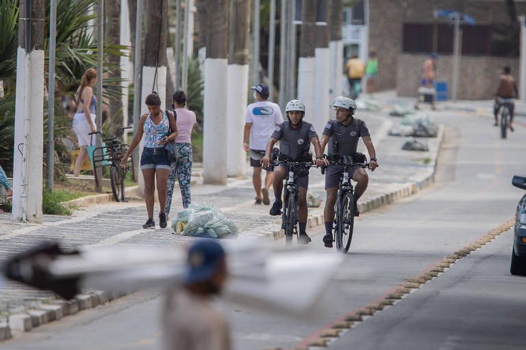 Polícia fazem ronda em cima de bicicletas na orla da praia em Guarujá 