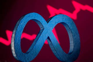 FILE PHOTO: A 3D-printed Facebook's new rebrand logo Meta is seen in front of displayed stock graph in this illustration