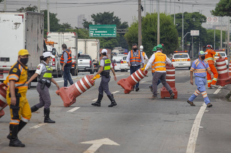 Agentes da CET retiram cones para liberar trânsito da pista central da marginal Tietê