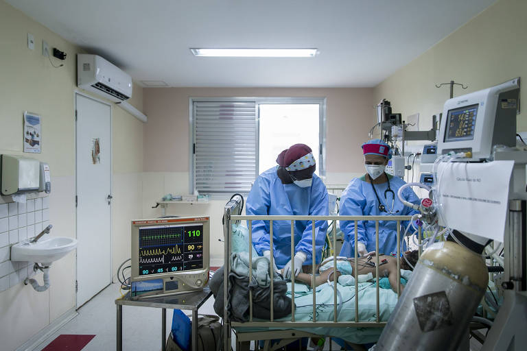 Profissionais de saúde, com avental cirúrgico, em UTI contra Covid de hospital estadual de São Paulo