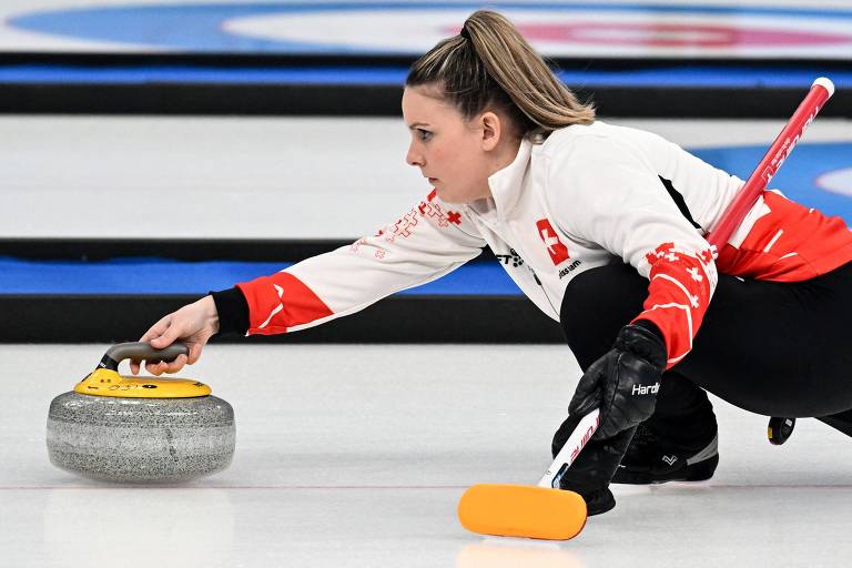 A suíça Jenny Perret manuseia a pedra de curling durante os Jogos de Inverno de Pequim 2022
